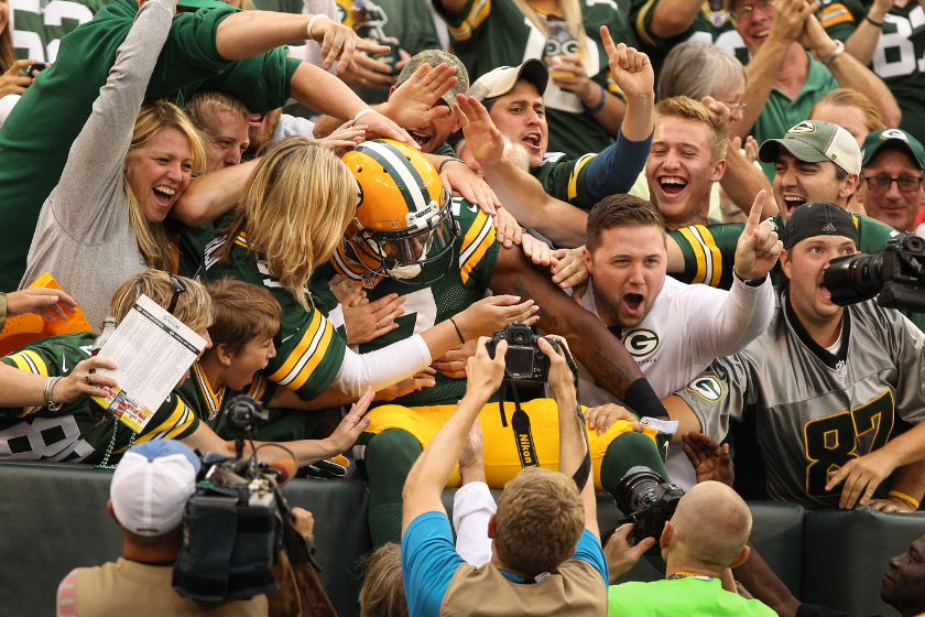 Davante Adams #17 of the Green Bay Packers jumps into the crowd after scoring in the first quarter in the preseason game