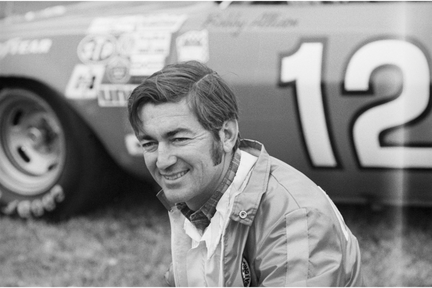 Bobby Allison sits in front of stock car in 1973
