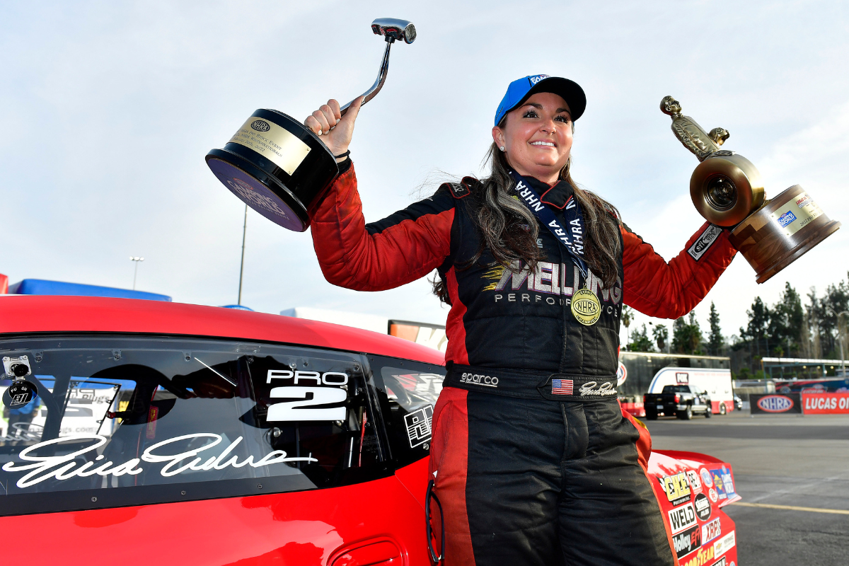 Erica Enders celebrates with a special trophy after winning the 900th Pro Stock event at the 62nd annual NHRA Winternationals at Auto Club Raceway at Pomona on Feb. 20, 2022