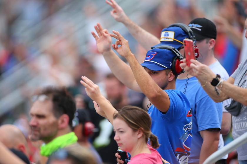 Fans hold up three fingers to salute NASCAR legend Dale Earnhardt, who passed away 20 years ago, during the Daytona 500 on February 14, 2021 at Daytona International Speedway