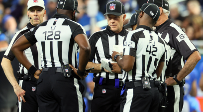NFL referees circling up during a game between the Green Bay Packers and Detroit Lions.