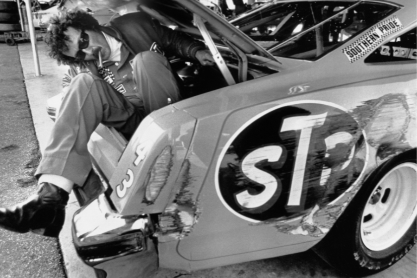 Richard Petty sits in the trunk of Oldsmobile and kicks out the side of his rear fender in 1979