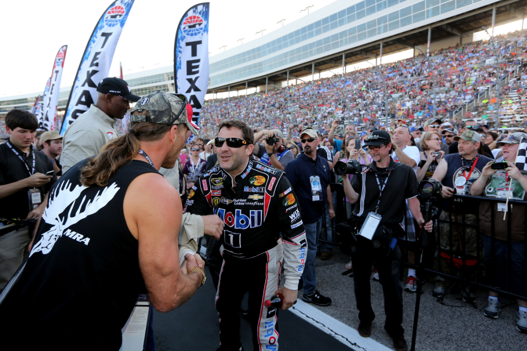 Tony Stewart greets former wrestler Shawn Michaels during pre-race ceremonies for the 2013 NRA 500 at Texas Motor Speedway