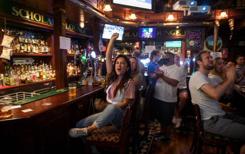 An excited sports fan reacts at a bar.