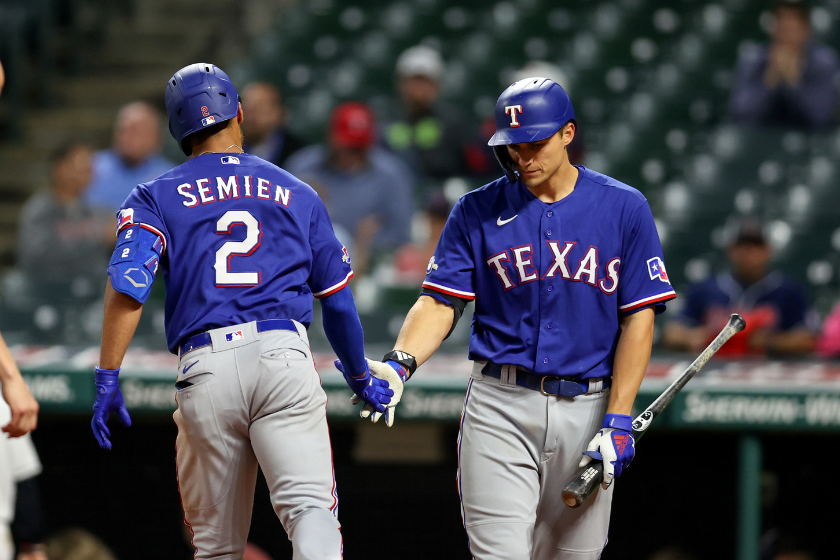 Corey Seager meets Marcus Semien at home plate during.a Texas Rangers game.
