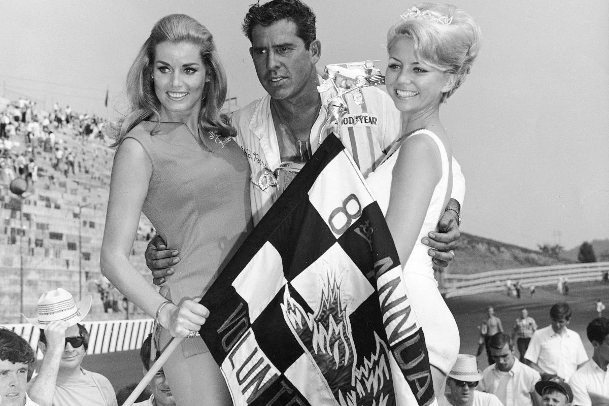 black and white photo of david pearson with woman on either side