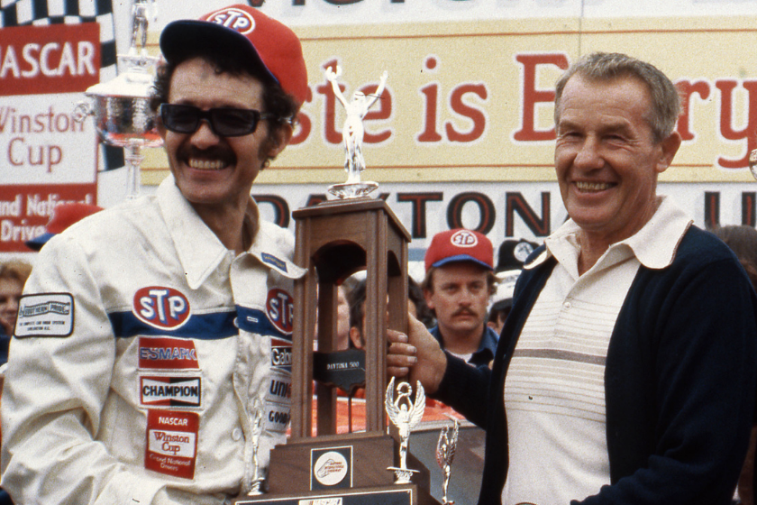 Richard Petty proudly displays the Daytona 500 trophy with his father Lee