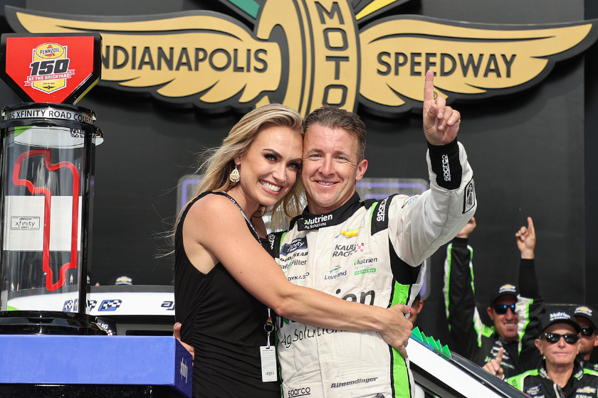 AJ Allmendinger and his wife Tara celebrate in victory lane after winning the 2022 Pennzoil 150 at the Brickyard at Indianapolis Motor Speedway on July 30