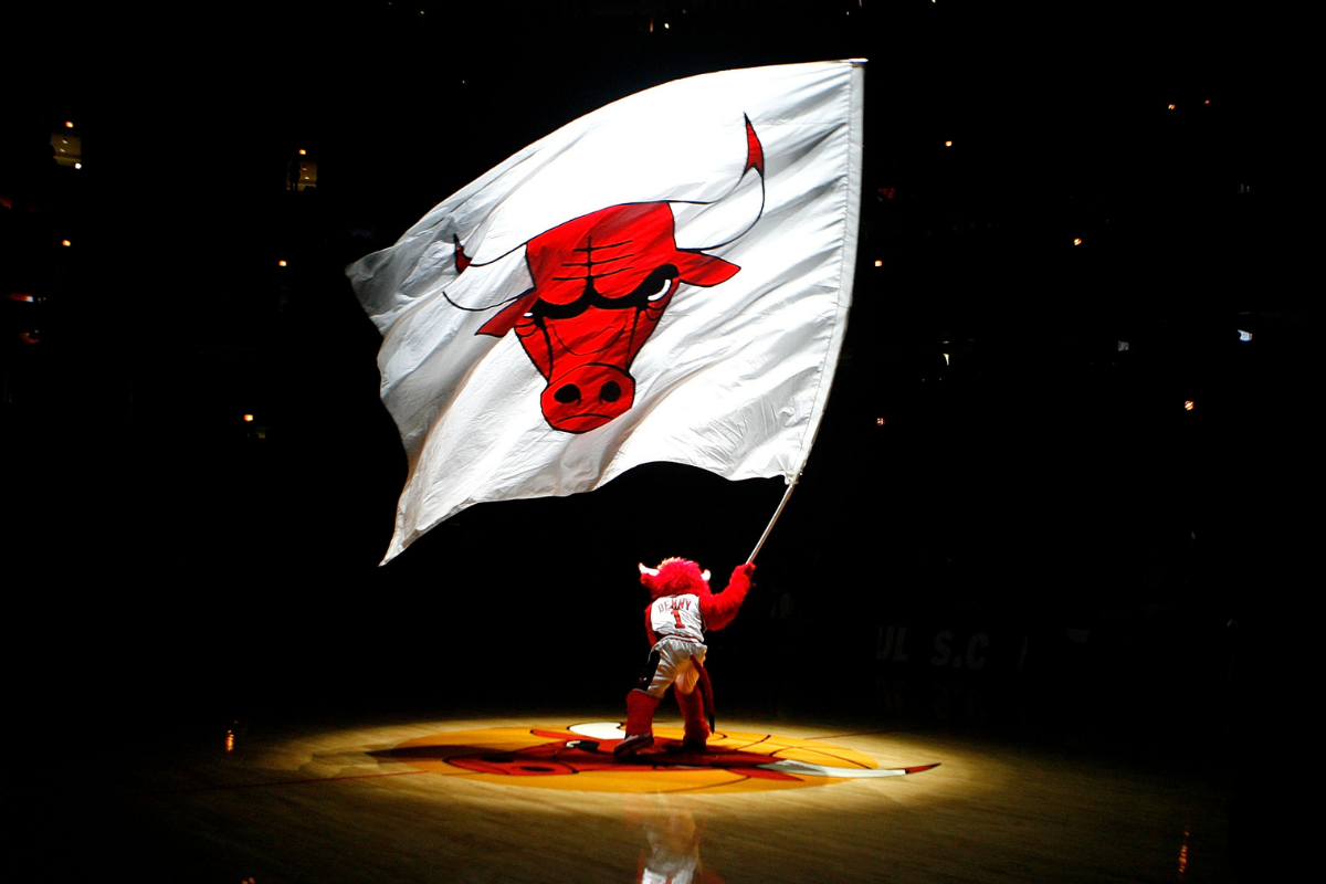 Benny the Bull waves a flag with the Bulls logo on it.