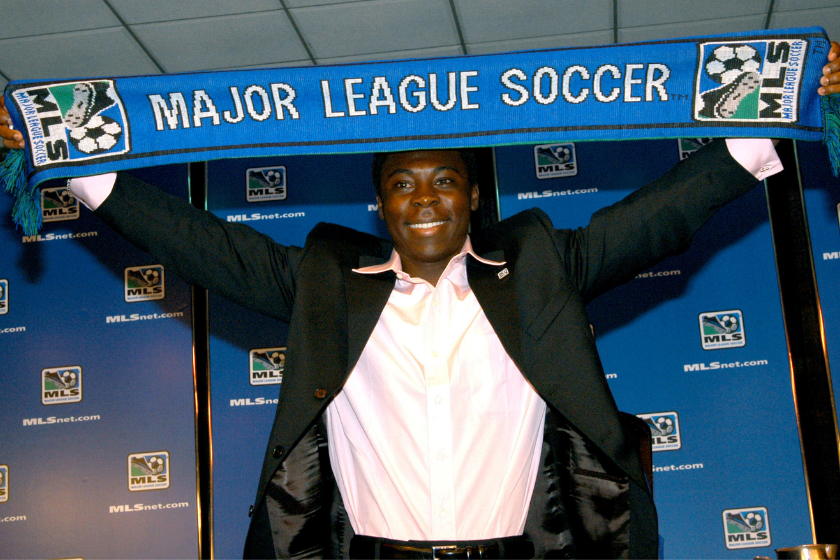 Freddy Adu holds up a Major League Soccer Scarf after signing with DC United at age 14.