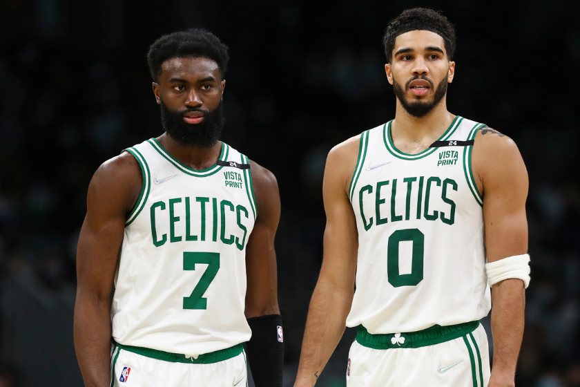 Jaylen Brown and Jayson Tatum watch as a teammate shoots free throws. 