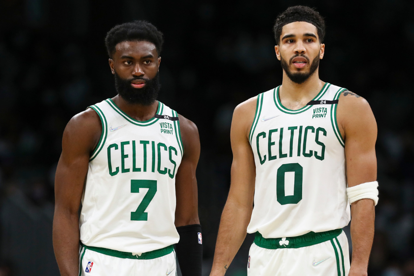 Jaylen Brown and Jayson Tatum watch as a Celtics teammate shoots free throws.