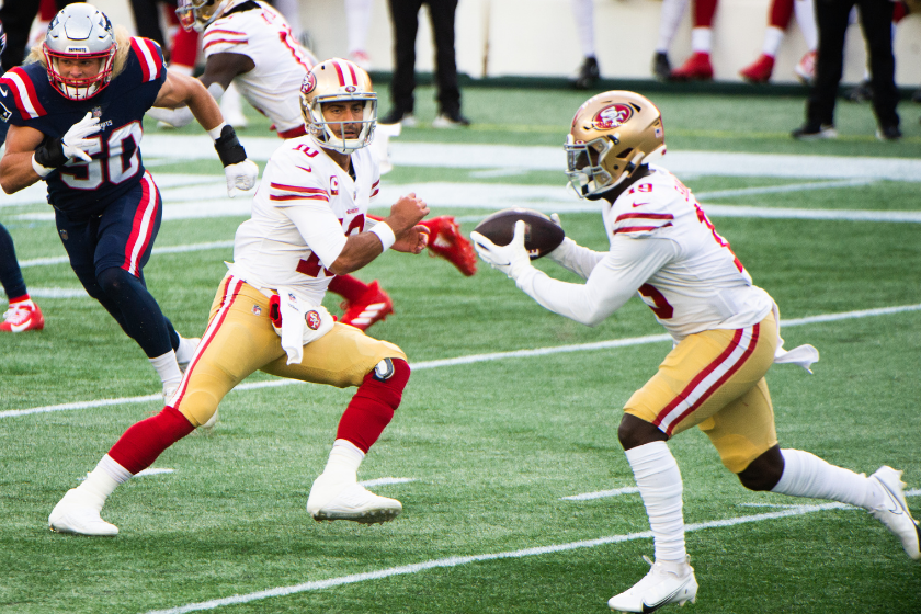 Jimmy Garoppolo hands off the ball to Deebo Samuel during a 49ers game agains the New England Patriots