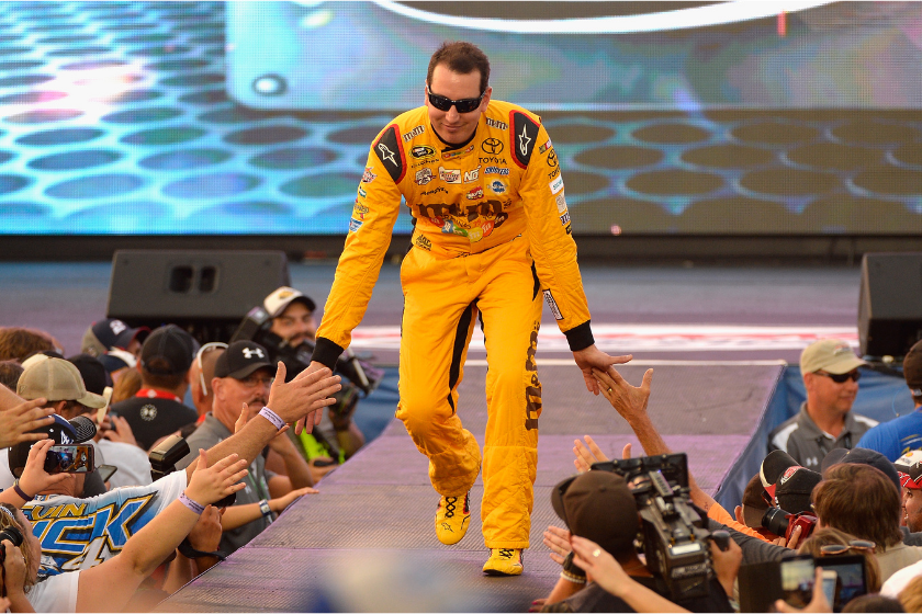 Kyle Busch high fives fans during driver introductions prior to the NASCAR Sprint Cup Series Federated Auto Parts 400 at Richmond International Raceway on September 10, 2016 in Richmond, Virginia