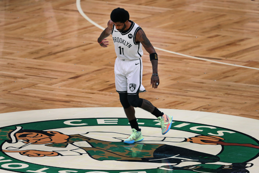 Kyrie Irving wipes his shoes on the "Lucky" the Celtics Logo