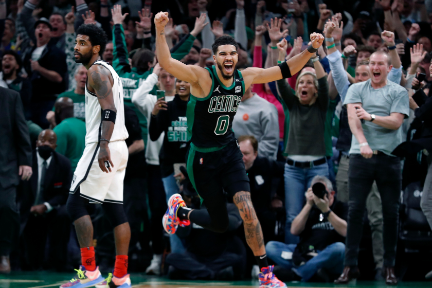 Jayson Tatum celebrates a buzzer-beating shot for the Celtics as Kyrie Irving looks on.