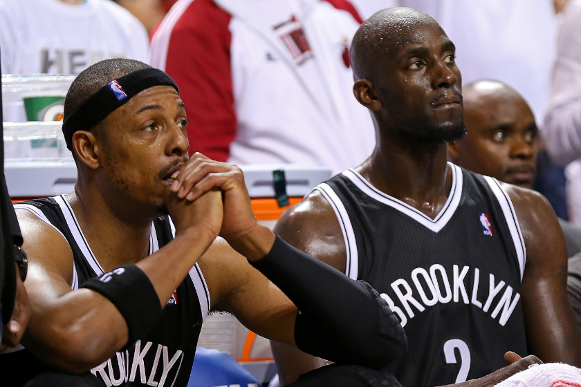 Paul Pierce and Kevin Garnett watch a play unfold from the Boorklyn Nets bench.