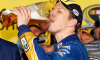 Brad Keselowski drinks a beer in front of NASCAR chairman and CEO Brian France in Champions Victory Lane after winning the series championship and finishing in fifteenth place for the NASCAR Sprint Cup Series Ford EcoBoost 400 at Homestead-Miami Speedway on November 18, 2012 in Homestead, Florida