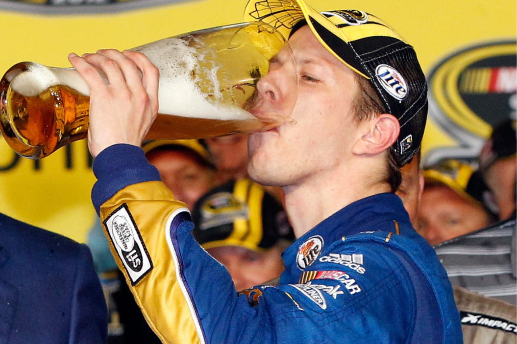 Brad Keselowski drinks a beer in front of NASCAR chairman and CEO Brian France in Champions Victory Lane after winning the series championship and finishing in fifteenth place for the NASCAR Sprint Cup Series Ford EcoBoost 400 at Homestead-Miami Speedway on November 18, 2012 in Homestead, Florida