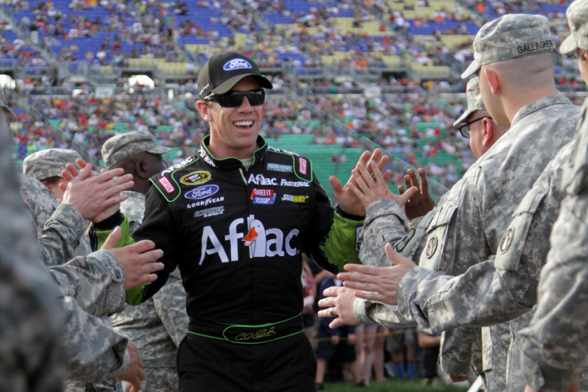Carl Edwards high-fives members of the military during pre-race driver introductions prior to the NASCAR Sprint Cup Series 5-Hour Energy 400 at Kansas Speedway on May 10, 2014 in Kansas City, Kansas