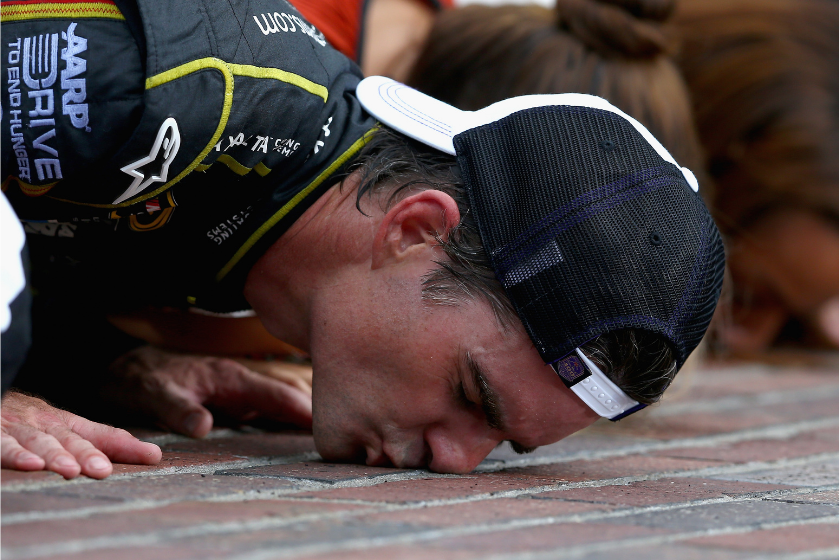 Jeff Gordon, driver of the #24 Axalta Chevrolet, celebrates by kissing the bricks after winning the NASCAR Sprint Cup Series Crown Royal Presents The John Wayne Walding 400 at the Brickyard Indianapolis Motor Speedway on July 27, 2014 in Indianapolis, Indiana