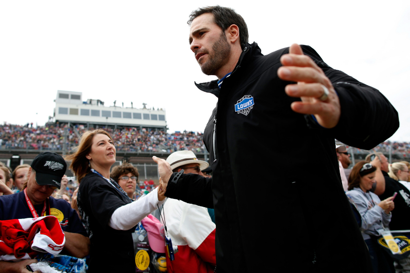 Jimmie Johnson high-fives a fan prior to the NASCAR Sprint Cup Series Good Sam Roadside Assistance 500 at Talladega Superspeedway on October 7, 2012 in Talladega, Alabama