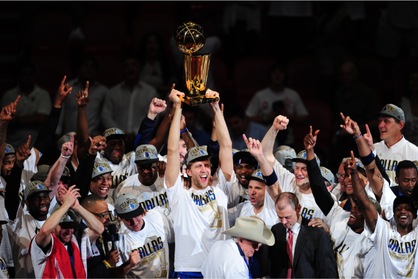 Dirk Nowitzki hoists the Larry O'Brien Trophy after the Dallas Mavericks win the 2011 NBA championship.