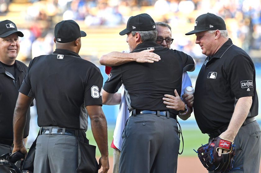 Dale Scott hugs umpires during Pride night at a Dodgers game in 2018.