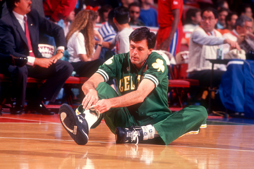Kevin McHale ties his sneakers before the tipoff of a Celtics game. 