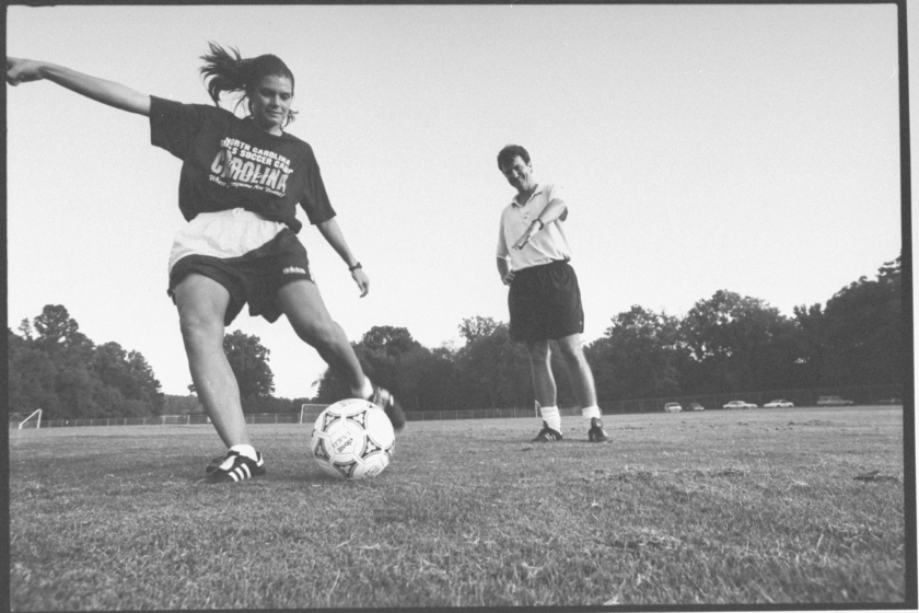 Mia Hamm practices under the eye of UNC Women's Soccer Coach Anson Dorrnace.