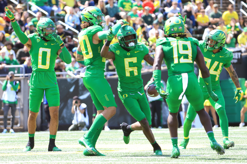 Members of the Oregon Ducks football team celebrate an interception during their spring game..