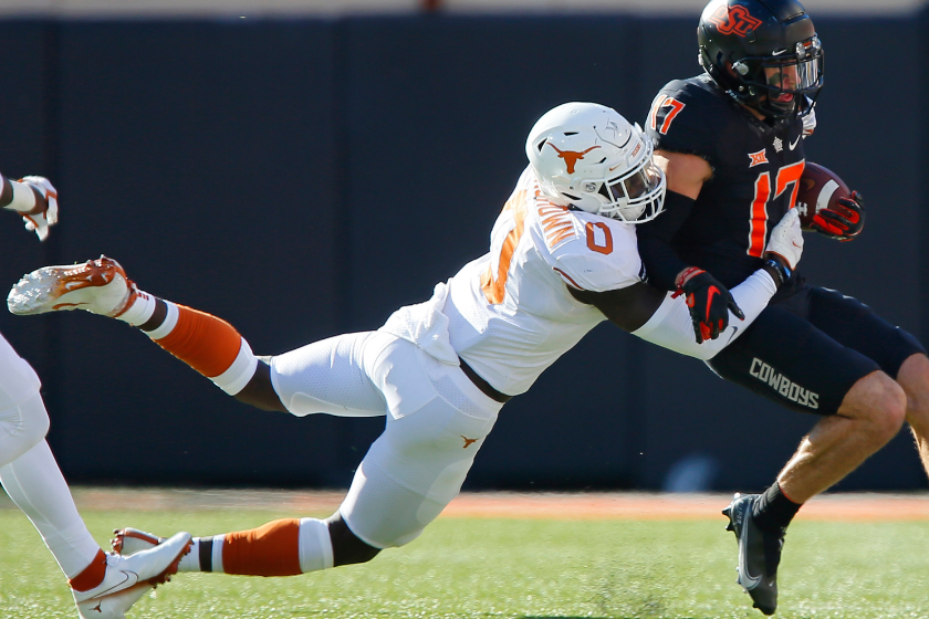 DeMarvion Overshown brings down punt returner Dillon Stone of the Oklahoma State Cowboys