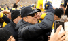 Head Coach Jim Harbaugh of the Michigan Wolverines celebrates with fans after defeating the Ohio State Buckeyes