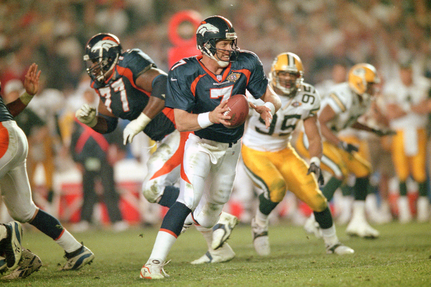 John Elway scrambles during a Denver Broncos play in Super Bowl XXXII against the Green Bay Packers