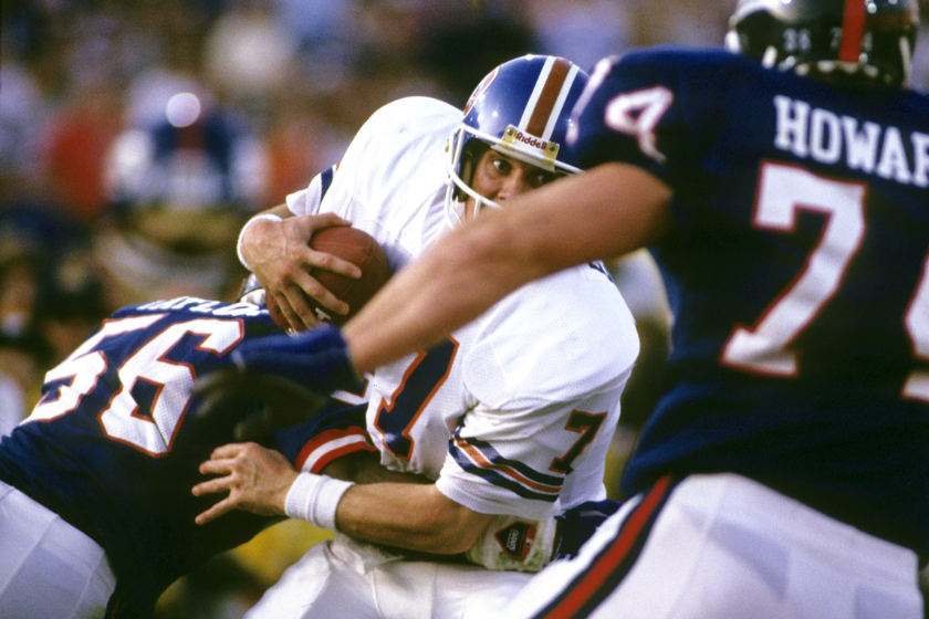 Denver Broncos quarterback John Elway is stopped by New York Giants linebacker Lawrence Taylor in Super Bowl XXI