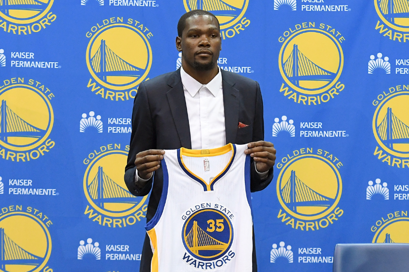 Kevin Durant #35 of the Golden State Warriors poses with his new jersey during the press conference where he was introduced as a member of the Golden State Warriors