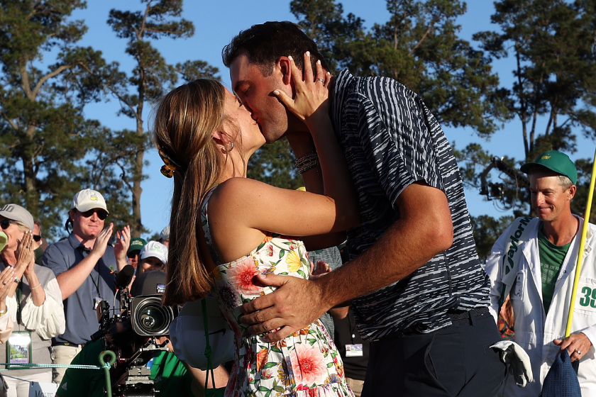 Scottie Scheffler and wife Meredith Scheffler celebrate on the 18th green after Scheffler won the Masters at Augusta National Golf Club