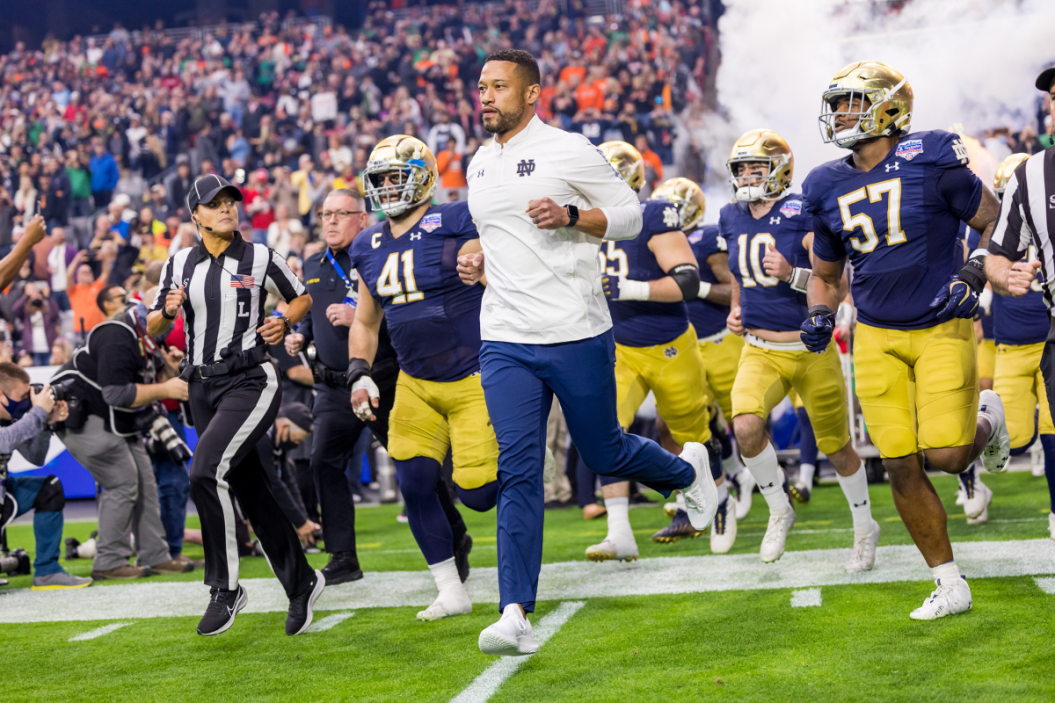 Notre Dame head coach Marcus Freeman leads his team onto the field for the Fiesta Bowl.