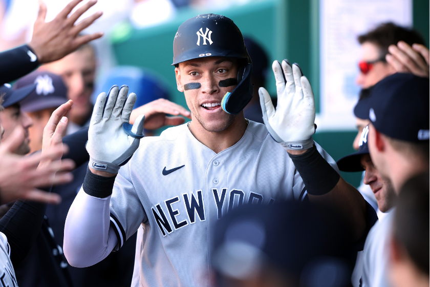 Aaron Judge #99 of the New York Yankees is congratulated by teammates in the dugout after hitting a solo home run during the 9th inning of the game against the Kansas City Royals
