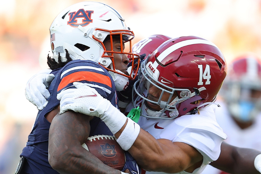 Brian Branch #14 of the Alabama Crimson Tide tackles Tank Bigsby #4 of the Auburn Tigers