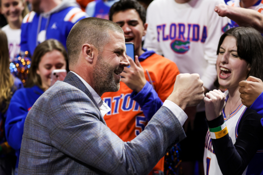 Head football coach Billy Napier of the Florida Gators meets with fans during halftime of a basketball game