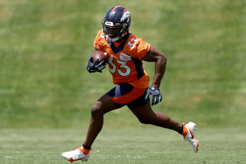 Javonte Williams #33 of the Denver Broncos runs with the ball on the field during a mandatory mini-camp