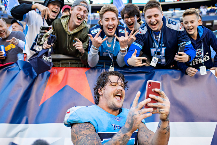 Taylor Lewan #77 of the Tennessee Titans takes a selfie with fans after of a game against the Kansas City Chiefs
