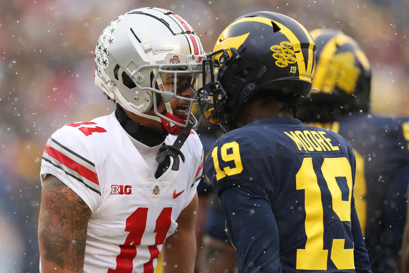 Jaxon Smith-Njigba #11 of the Ohio State Buckeyes and Rod Moore #19 of the Michigan Wolverines talk during the first quarter