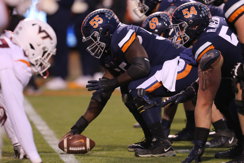 Virginia Cavaliers center Olusegun Oluwatimi (55) and the offensive line in the trenches during a game against the Virginia Tech Hokies
