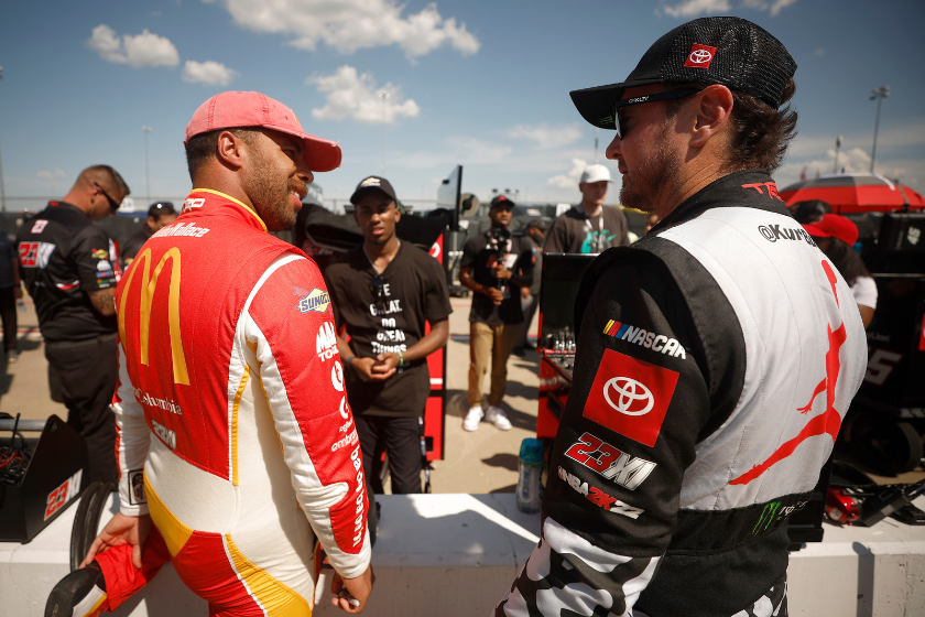 bubba wallace and kurt busch talk on the grid during practice for the NASCAR Cup Series AdventHealth 400 at Kansas Speedway on May 14, 2022