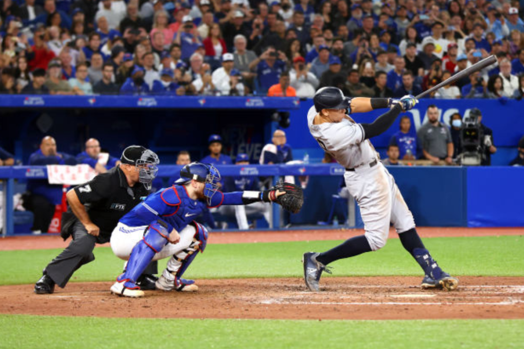 Aaron Judge #99 of the New York Yankees hits his 61st home run of the season in the seventh inning against the Toronto Blue Jays at Rogers Centre