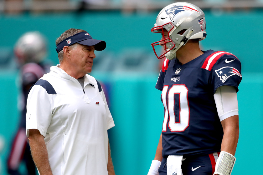 Head coach Bill Belichick and Mac Jones #10 of the New England Patriots talk on the field prior to a game against the Miami Dolphins