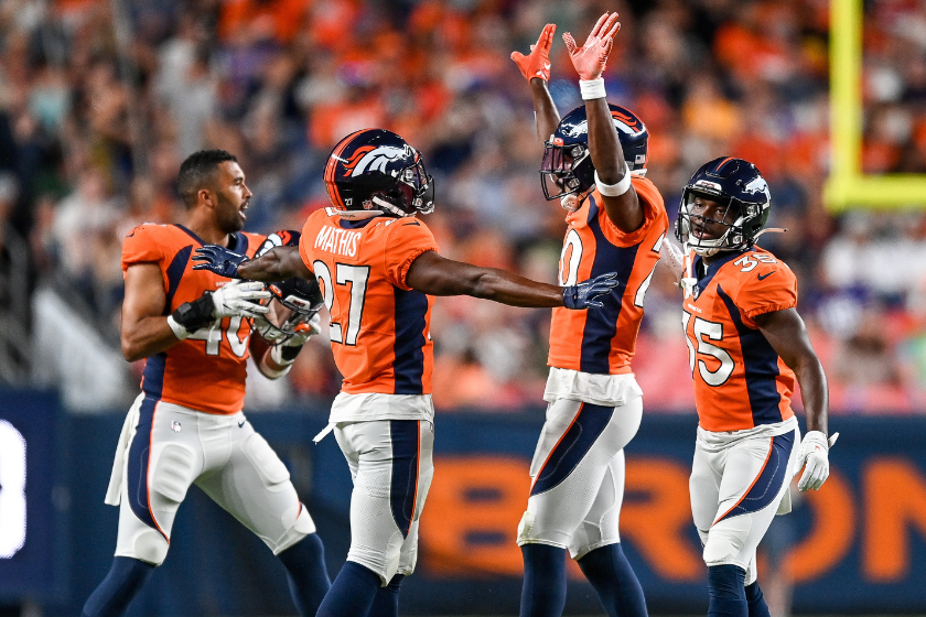 Safety J.R. Reed #20 of the Denver Broncos celebrates with cornerback Damarri Mathis #27, linebacker Justin Strnad #40, and cornerback Ja'Quan McMillian #35 after a defensive play in a preseason NFL game