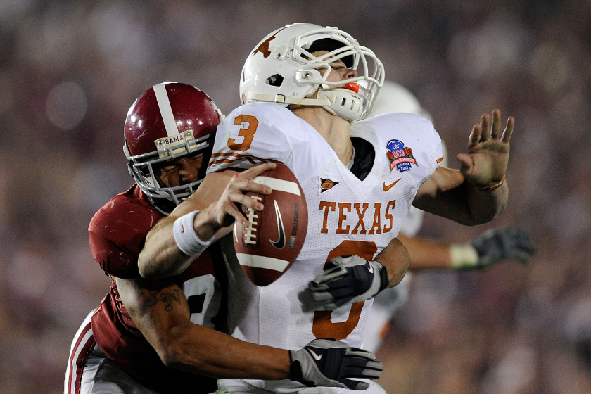 Quarterback Garrett Gilbert #3 of the Texas Longhorns fumbles the ball as he is hit by linebacker Eryk Anders #32 of the Alabama Crimson Tide during the 2010 Citi BCS National Championship game